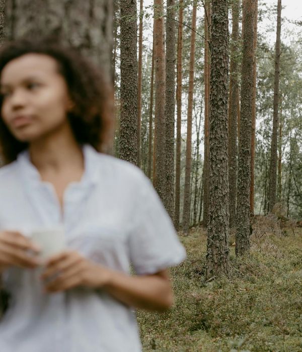 Person meditating peacefully outdoors with soft natural light.